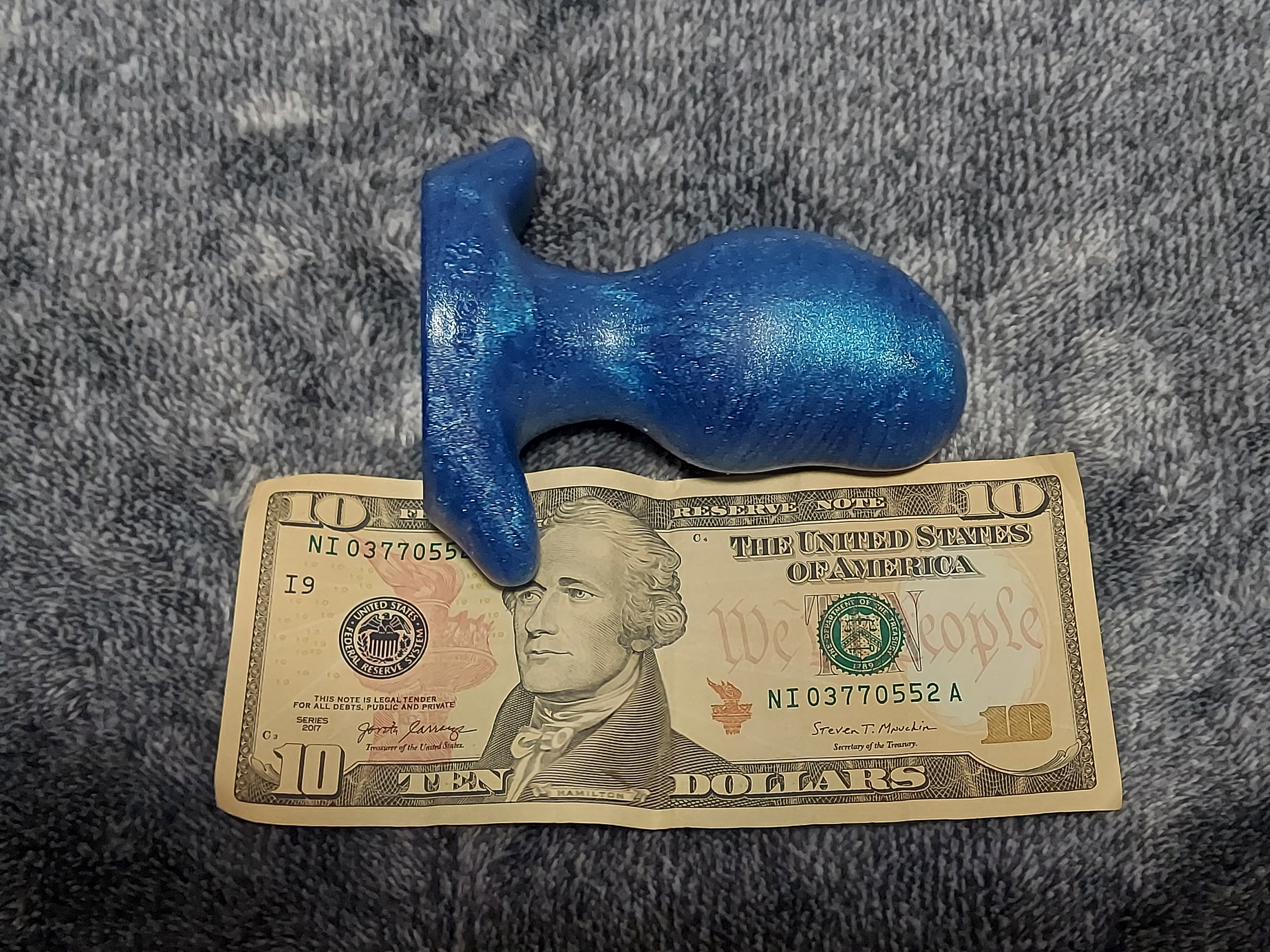 Size comparison of Oxballs ergo plug and ten dollar bill